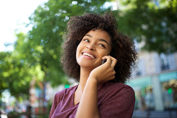 Wall Mural - young smiling african american woman talking with cellphone outdoors