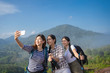 Group of asian woman hiker taking photo with smart phone at mountain peak.