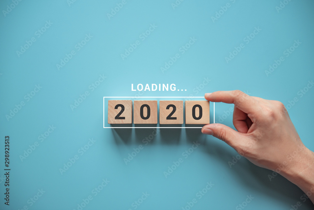 Loading new year 2020 with hand putting wood cube in progress bar. - obrazy, fototapety, plakaty 