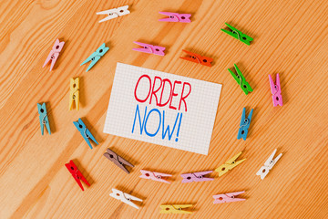 Text sign showing Order Now. Business photo text confirmed request by one party to another to buy sell Colored clothespin papers empty reminder wooden floor background office