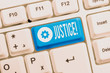 Text sign showing Justice. Business photo showcasing impartial adjustment of conflicting claims or assignments White pc keyboard with empty note paper above white background key copy space
