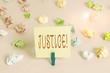 © Zofia - Writing note showing Justice. Business concept for impartial adjustment of conflicting claims or assignments Colored crumpled papers empty reminder pink floor background clothespin