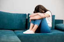 Young Woman Crying Feeling Very Depressed Sitting On The Sofa With Her Head Down Tough Life