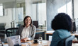 © mavoimages - Two smiling businesswoman talking together around an office table