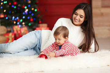 Canvas Print - Mother and her cute baby at home. Christmas celebration