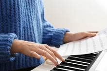 Young Woman Playing Piano At Home, Closeup