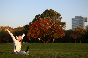 Wall Mural - happy teenage girl is listening to music on a laptop and enjoying a sunny autumn day