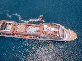 Large luxury cruise ship in the blue waters of the Andaman sea, 2 boats around; aerial view.