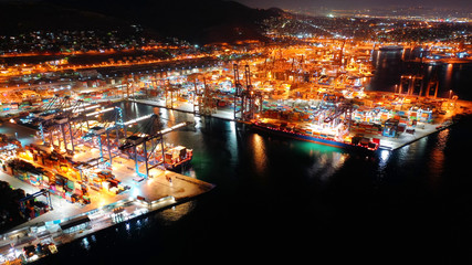 Aerial night shot of illuminated industrial cargo truck size container terminal in Asia port