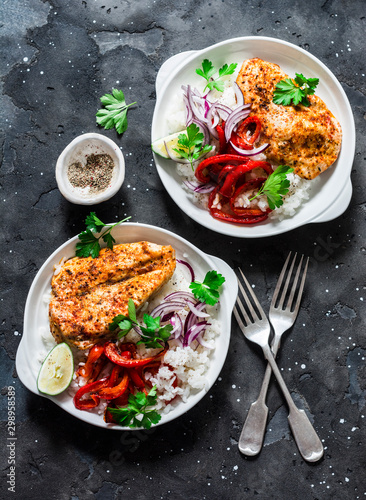 Fotomural Baked spicy chicken breast with sweet pepper and rice - delicious mexican style lunch on a dark background, top view