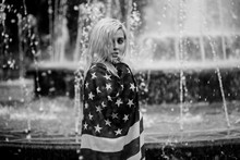 Beautiful Young Blond Woman On A City Background With American Flag