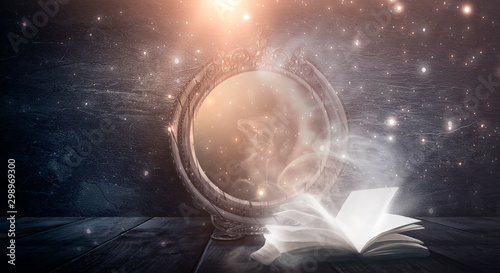 Fotografía An open book and a magic mirror against the backdrop of a night landscape