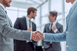 © ASDF - business partners shaking hands in the office
