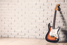 Modern Bass Guitar Near Brick Wall