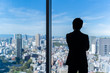 © taka - businessman wearing suit looking cityscape of tokyo