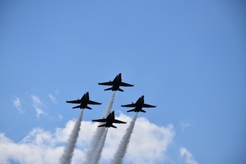 Sticker - Low angle shot of four fighter jets with big trails maneuvring in the sky during an air show