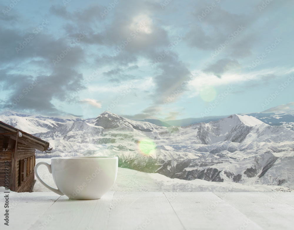 Single tea or coffee mug and landscape of mountains on background. Cup of hot drink with snowly look and cloudly sky in front of it. Warm in winter day, holidays, travel, New Year and Christmas time. - obrazy, fototapety, plakaty 