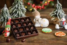 Assortment Of Fine Chocolate Candies, White, Dark, And Milk Chocolate Sweets Background. Christmas Interior With Gift Boxes And Christmas Fires