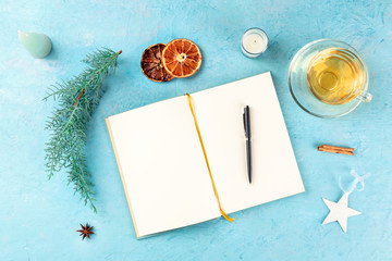 Wall Mural - New Year resolutions, flat lay top shot with copyspace, on a blue background with Christmas decorations and hot tea