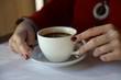 © Olga - woman holding a cup of coffee in her hands