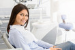 © Prostock-studio - Brunette female patient sitting on dentist chair and smiling