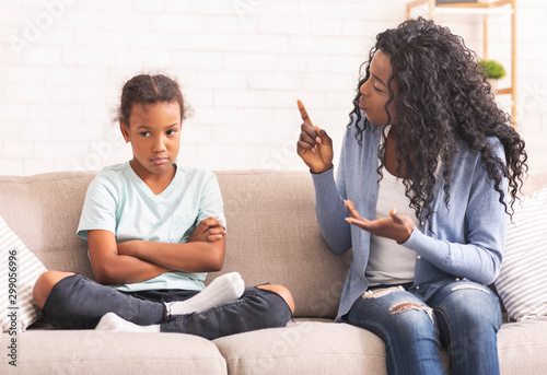 Fotomural Angry black mom scolding naughty little daughter at home