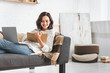 © LIGHTFIELD STUDIOS - attractive cheerful girl studying online with notepad, earphones and laptop