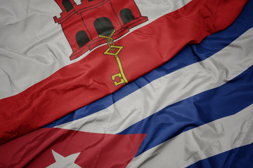 waving colorful flag of cuba and national flag of gibraltar.