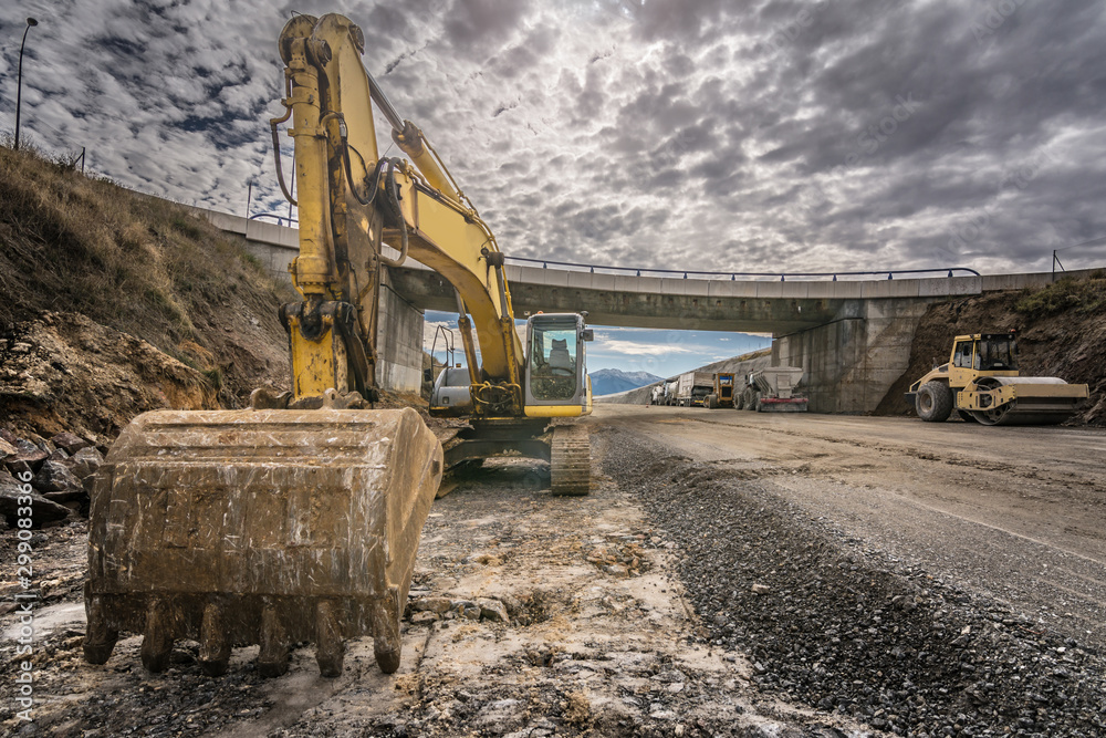 Excavator in the construction of a highway - obrazy, fototapety, plakaty 