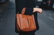 street style 2019, attractive woman wearing a satin top, black blazer and a tan brown tote bag, crossing the street. fashion outfit perfect for fall.