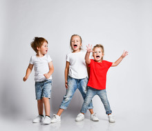 Happy Funky Kids Playing Screaming With Hands Up In Jeans. Happiness, Childhood, Freedom, Movement 