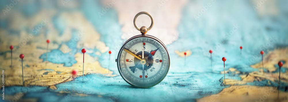 Magnetic compass  and location marking with a pin on routes on world map. Adventure, discovery, navigation, communication, logistics, geography, transport and travel theme concept background..  - obrazy, fototapety, plakaty 