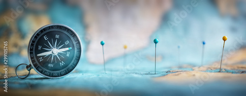 Fotografía Magnetic compass and location marking with a pin on routes on world map