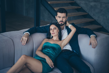 Poster - Photo of two classy people couple wealthy guy and lady lying close on comfy couch tenderness evening party look wear formalwear suit short mini shiny mini dress indoors