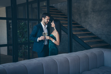 Poster - Profile photo of two classy stylish trendy people couple wealthy guy and lady standing close looking eyes drinking sparkling wine romance date wear fancy formalwear suit loft industrial indoors