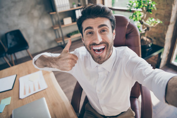 Great partnership online meeting. Close up photo of positive cheerful middle eastern entrepreneur make selfie show thumb up approve his new work clients sit chair in loft workstation