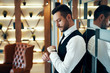 © GVS - Young business man in dark elegant suit looking at his watch