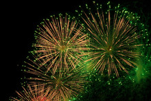 Red, Green And Golden Sparks Of Fireworks Exploding In The Sky And Smoke From The Charges
