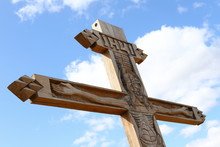 Orthodox Culture Exhibiting Wooden Cross With Crucifixion Against Blue Sky On Street Near Road Or Village, Part Of Christian Cross