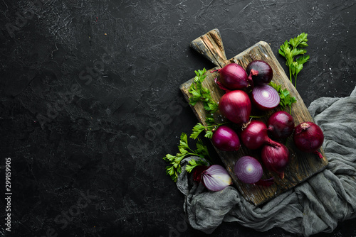 Fotografía Fresh red onions on black background. Top view. Free copy space.