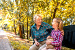 © Drpixel - Happy  grandmother and granddaughter having fun while eating popcorn in autumn park