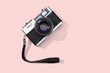 Flat lay film camera isolated on pink background. Copy space