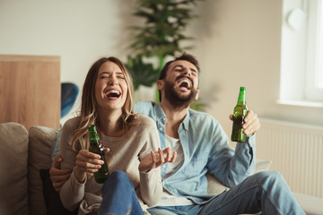 Wall Mural - Happy couple having fun while drinking beer at home