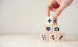 Leinwandbild Motiv Health Insurance Concept, Hand arranging wood cube stacking with icon healthcare medical on wood background, copy space, financial concept.