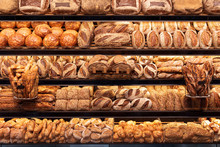 Bakery Shelf With Many Types Of Bread. Tasty German Bread Loaves On The Shelves