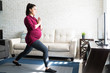 Beautiful Pregnant Female In Sportswear Exercising At Home