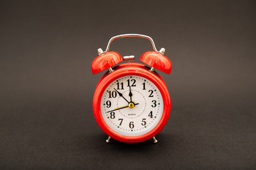 red alarm clock on black background