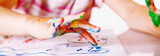 Close up young girl painting with colorful hands. Art,  creativity and painting concept. Horizontal image.