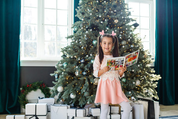 Wall Mural - Little girl looking at her photo book