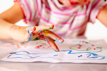 Young girl painting with colorful hands. Art,  creativity and painting concept.